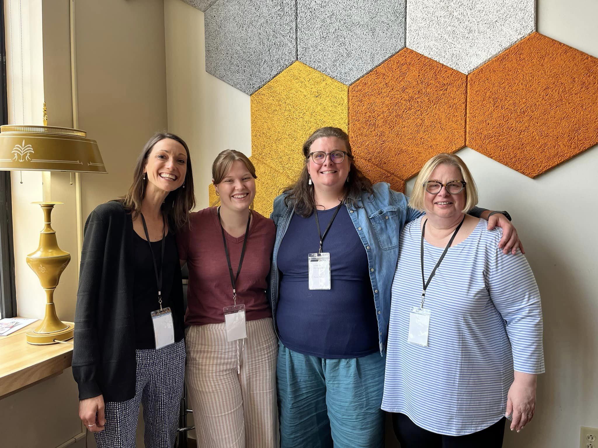 Four white women with lanyards.