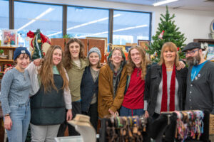 Eight people in winter clothes smiling in a store